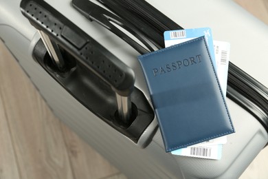 Photo of Passport with tickets on gray suitcase, above view