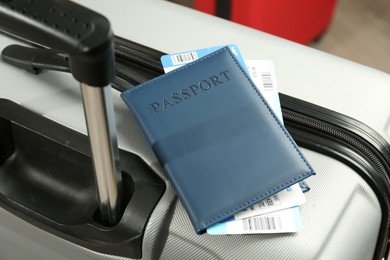 Photo of Passport with tickets on gray suitcase, closeup