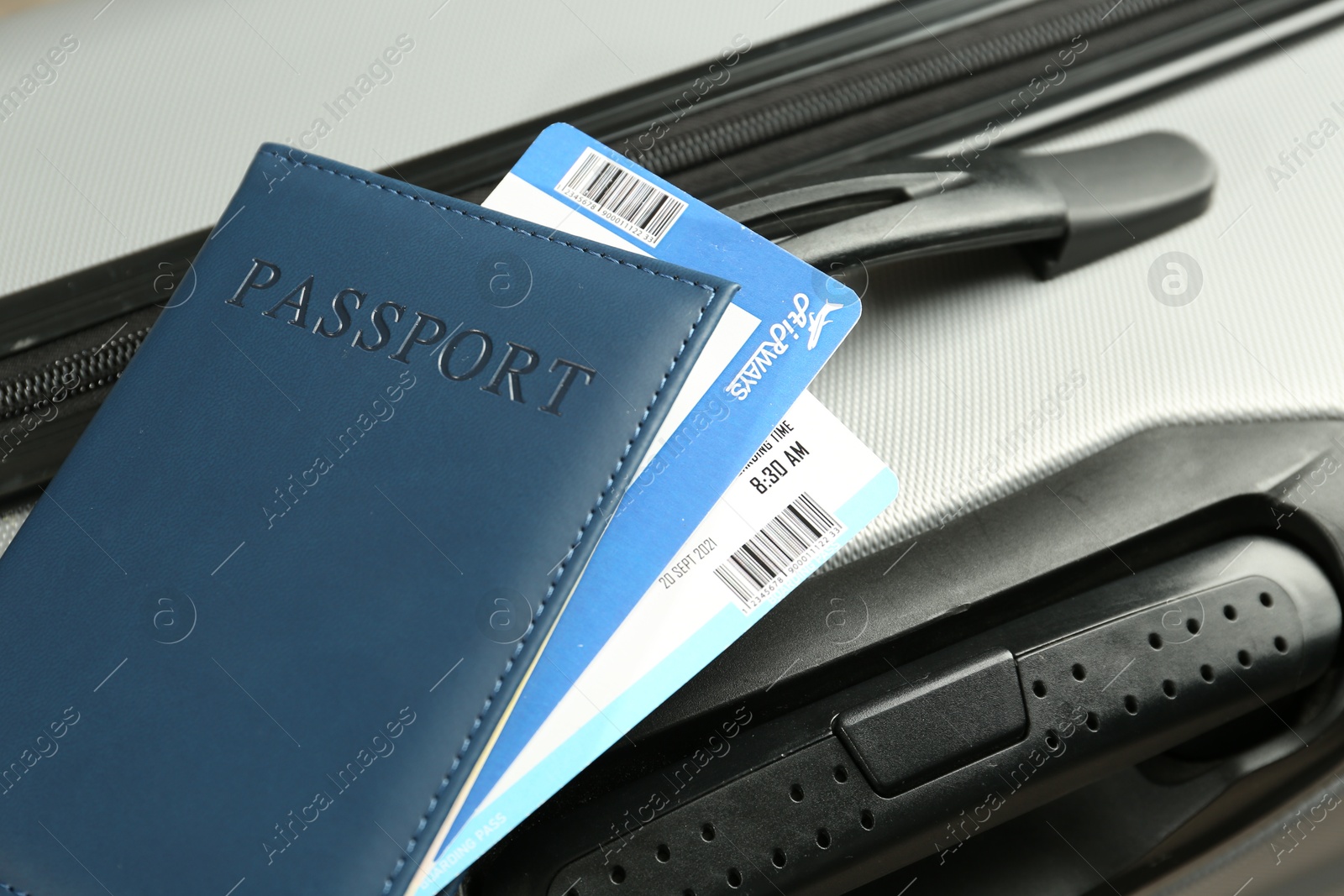 Photo of Passport with tickets on gray suitcase, closeup