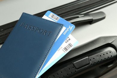 Photo of Passport with tickets on gray suitcase, closeup