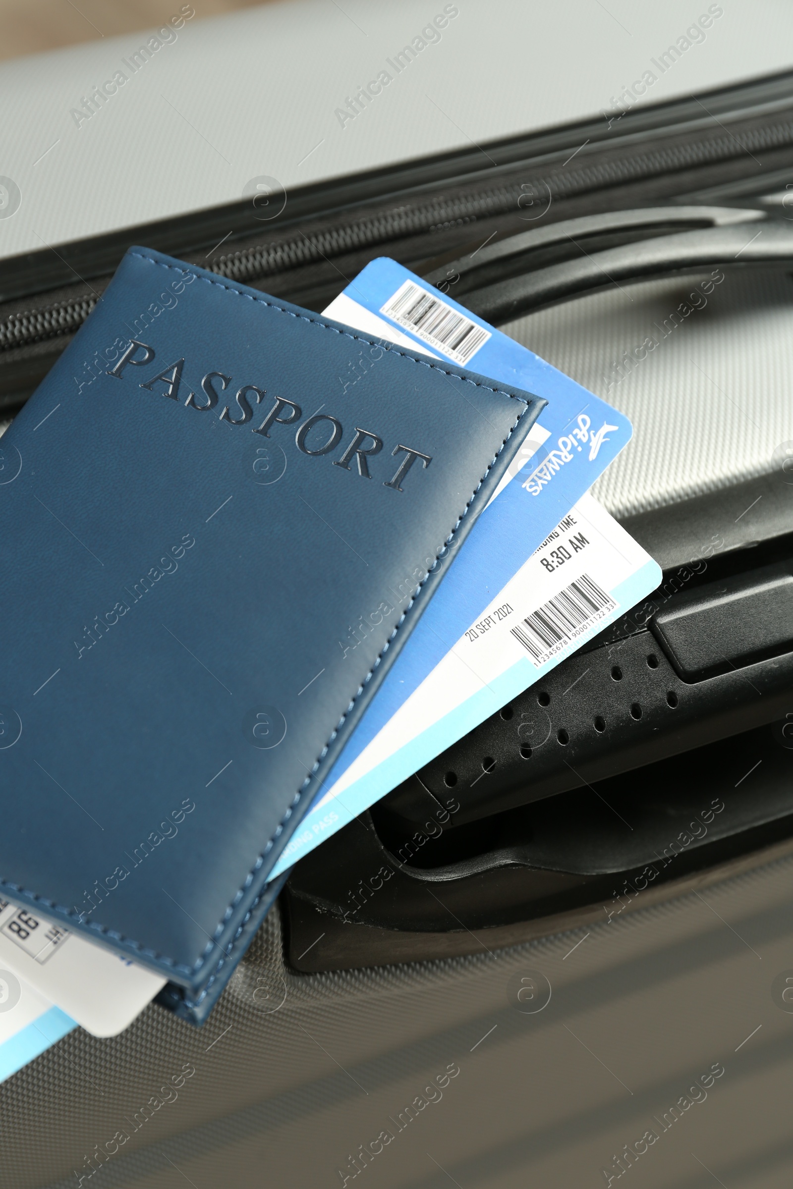 Photo of Passport with tickets on gray suitcase, closeup