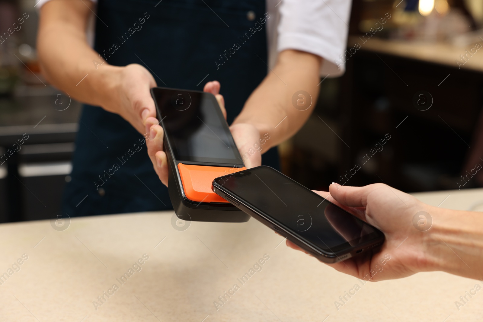 Photo of Woman paying with smartphone via terminal in cafe, closeup