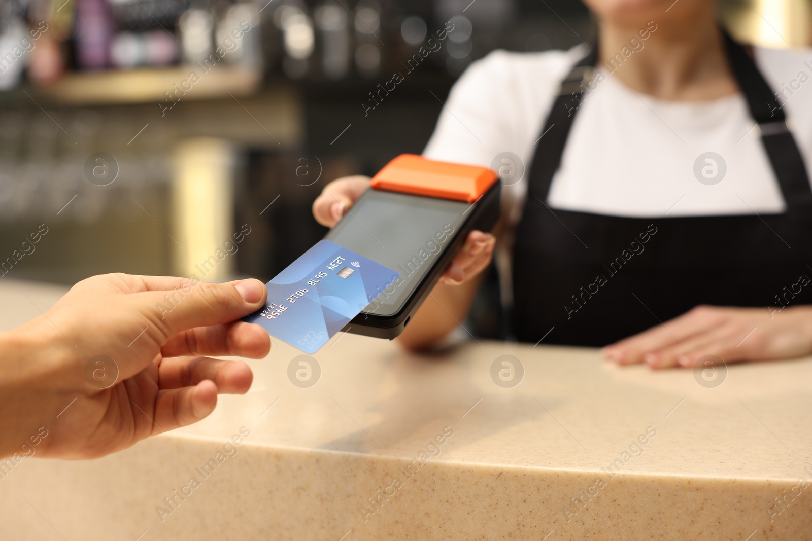 Photo of Man paying with credit card via terminal in cafe, closeup