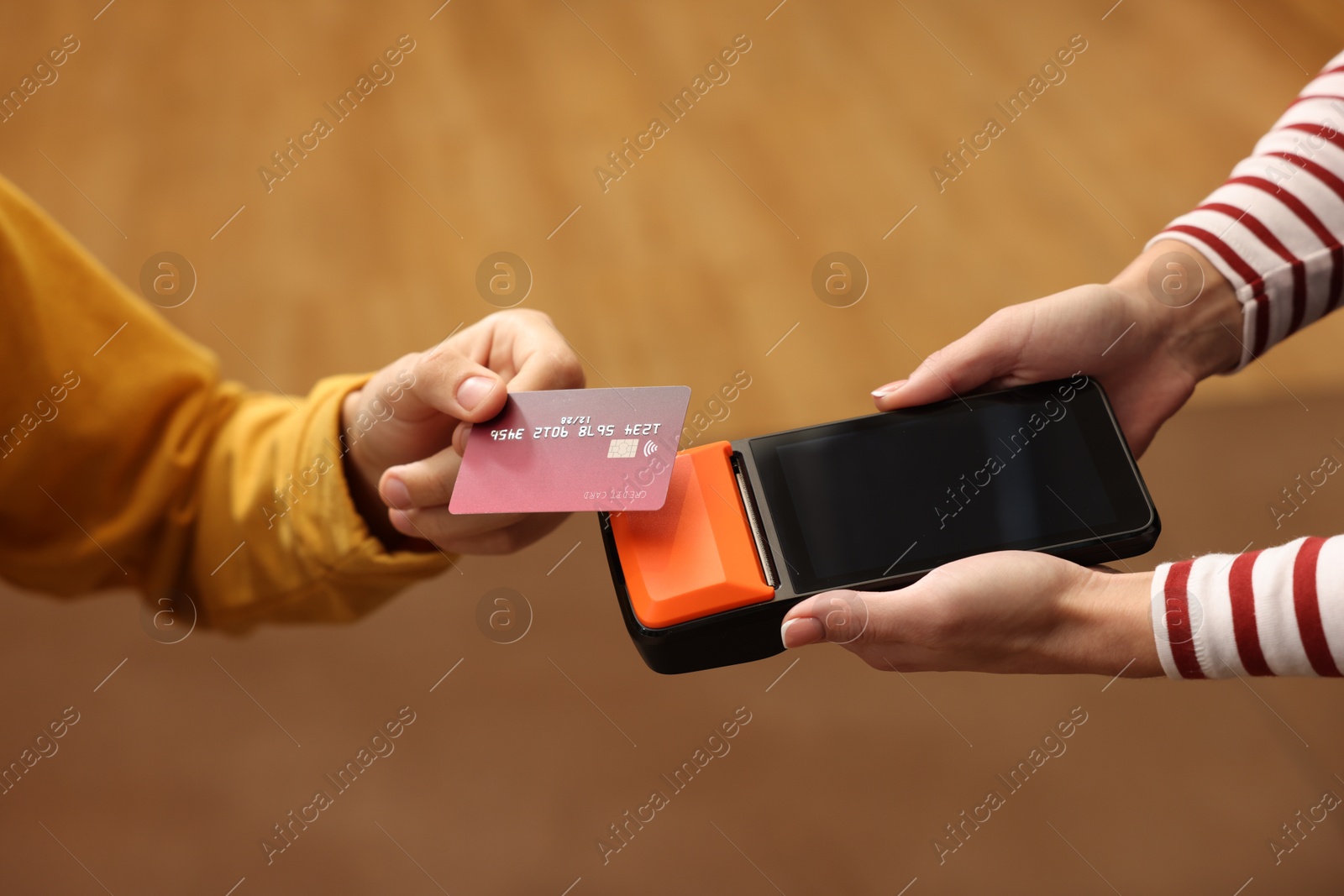 Photo of Man paying with credit card via terminal in cafe, closeup