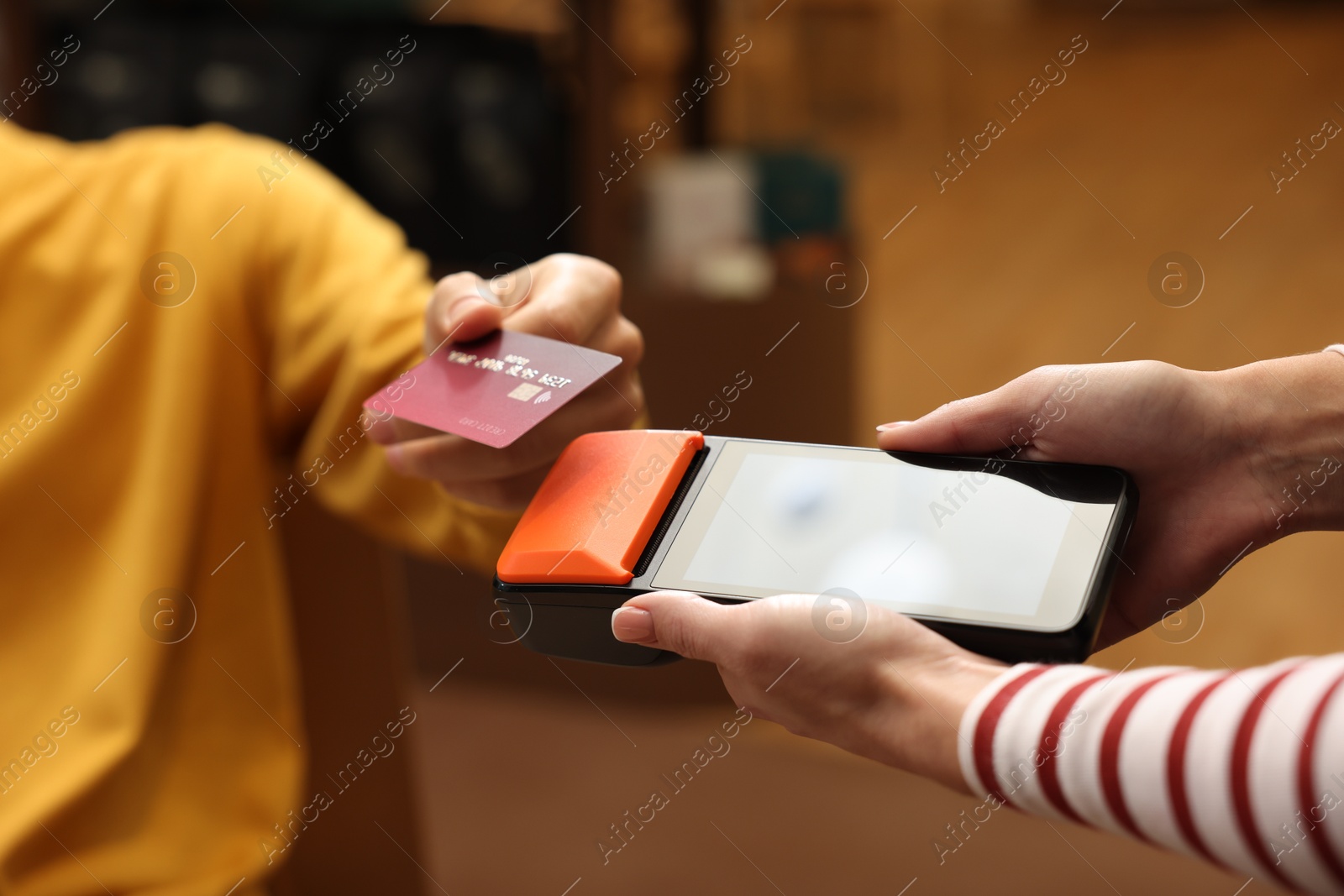 Photo of Man paying with credit card via terminal in cafe, closeup