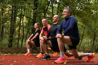 Photo of Group of people stretching in park. Healthy lifestyle