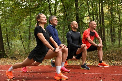 Photo of Group of people stretching in park. Healthy lifestyle