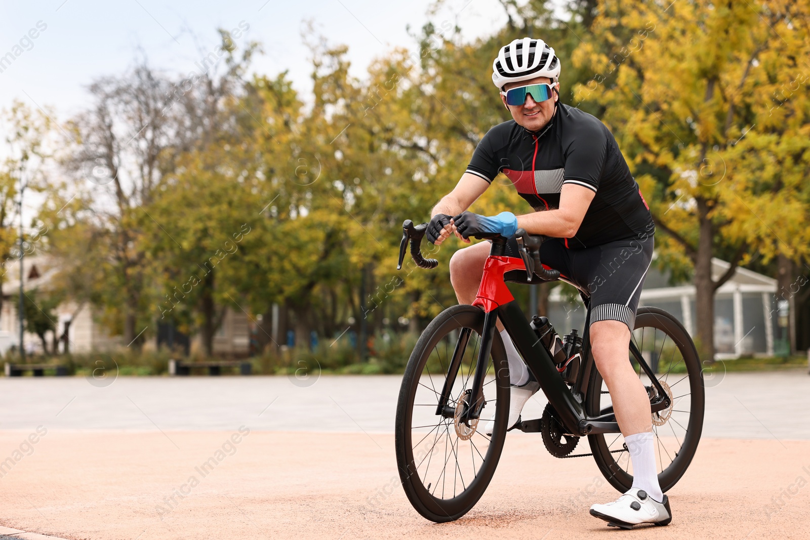 Photo of Athletic man with helmet and bicycle outdoors, space for text