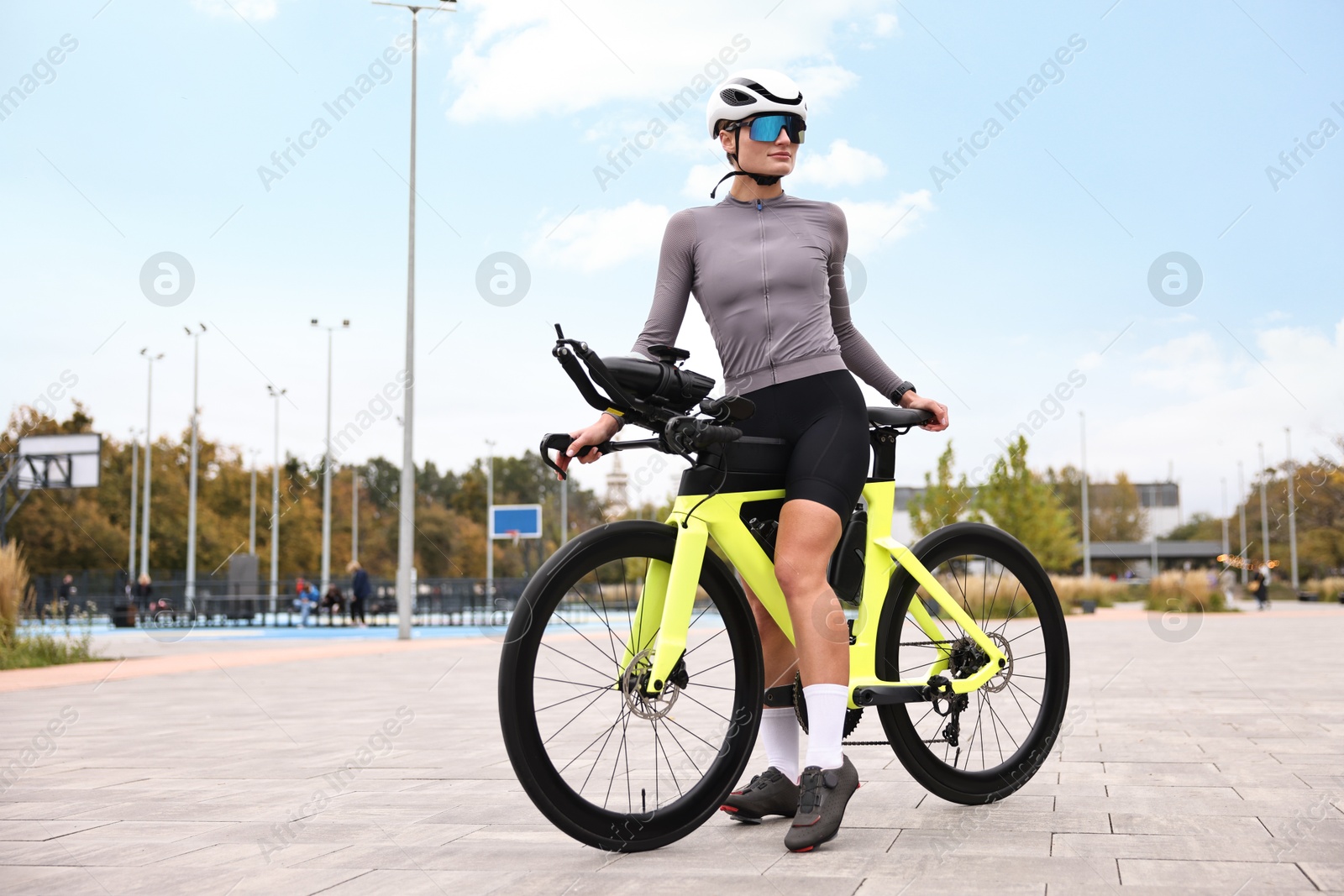 Photo of Young athletic woman with helmet and bicycle outdoors