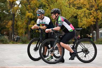 Photo of Athletic men with helmets and bicycles outdoors