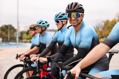 Photo of Group of athletic people with bicycles outdoors