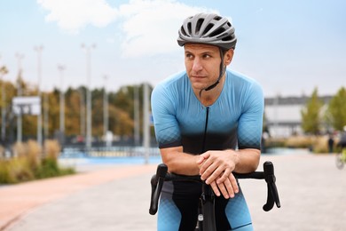 Photo of Athletic man with helmet and bicycle outdoors