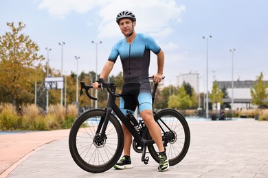 Photo of Athletic man with helmet and bicycle outdoors