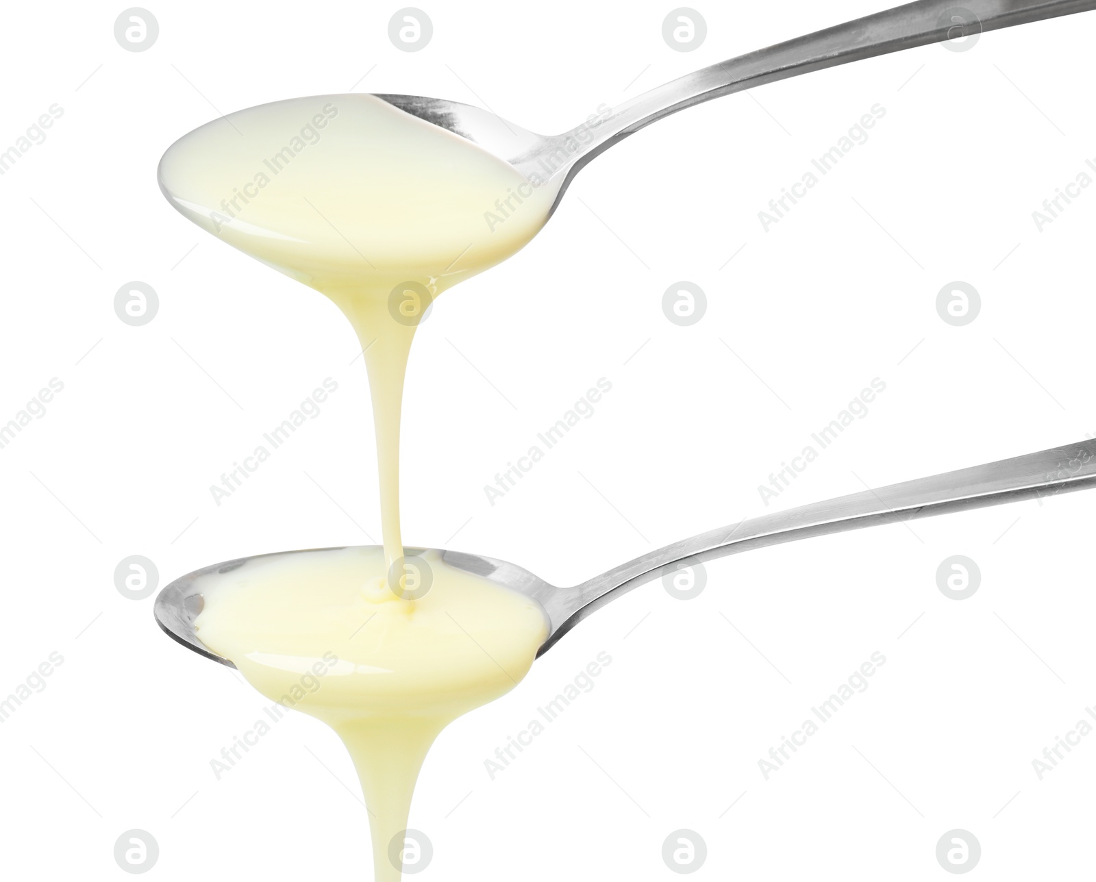 Photo of Condensed milk flowing down from spoons isolated on white