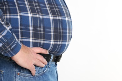 Photo of Overweight man in tight shirt on white background, closeup. Space for text