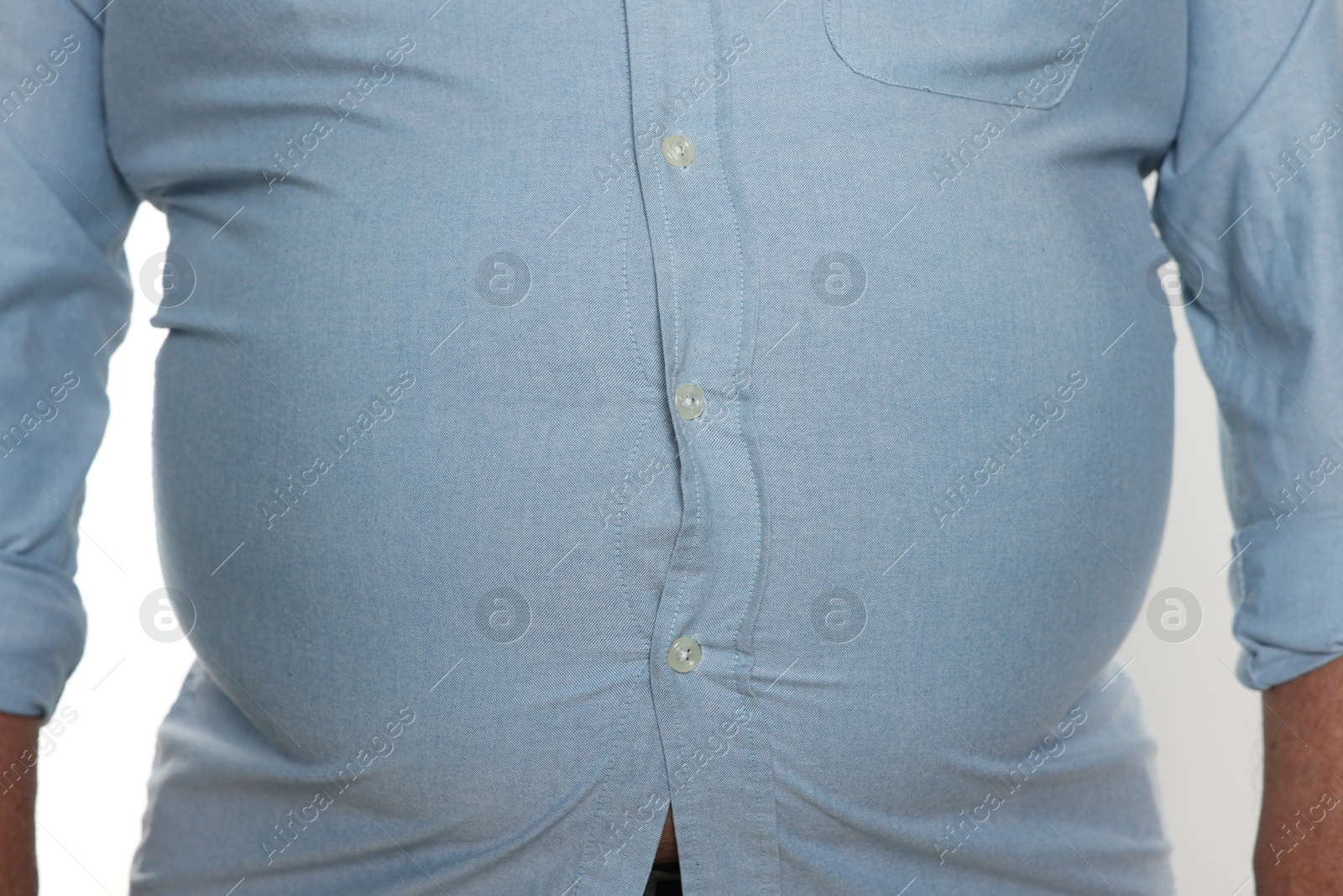 Photo of Overweight man in tight shirt on white background, closeup