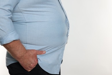 Photo of Overweight man in tight shirt on white background, closeup. Space for text