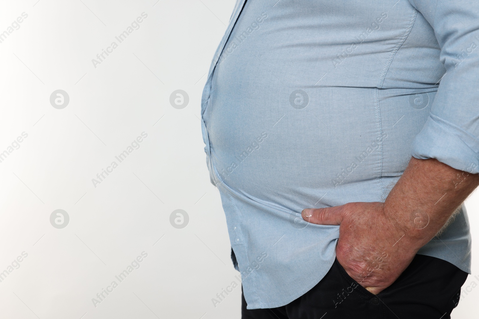 Photo of Overweight man in tight shirt on white background, closeup. Space for text