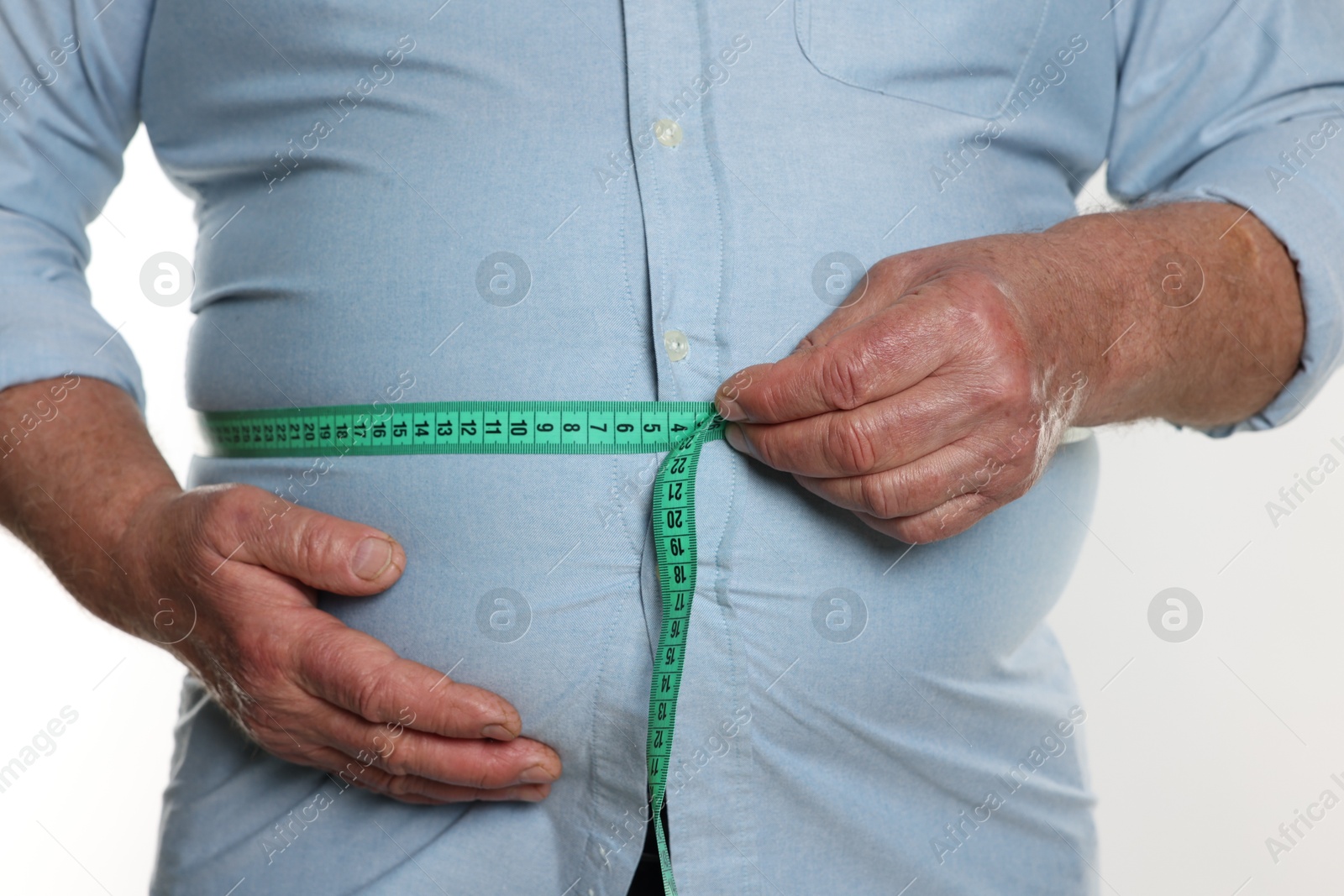 Photo of Overweight man measuring his belly with tape on white background, closeup