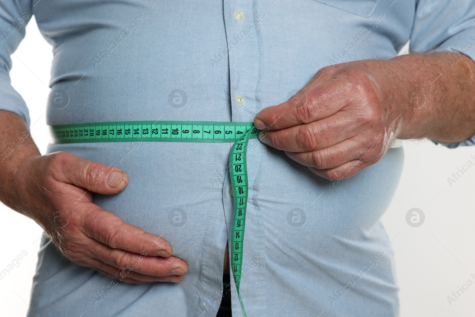 Photo of Overweight man measuring his belly with tape on white background, closeup