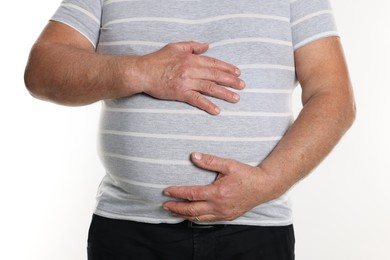 Photo of Overweight man in tight t-shirt on white background, closeup