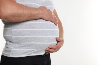 Photo of Overweight man in tight t-shirt on white background, closeup. Space for text