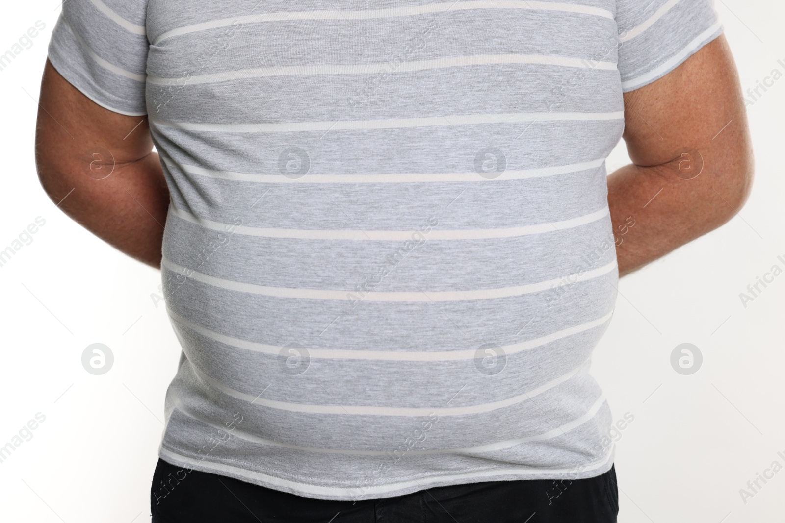 Photo of Overweight man in tight t-shirt on white background, closeup