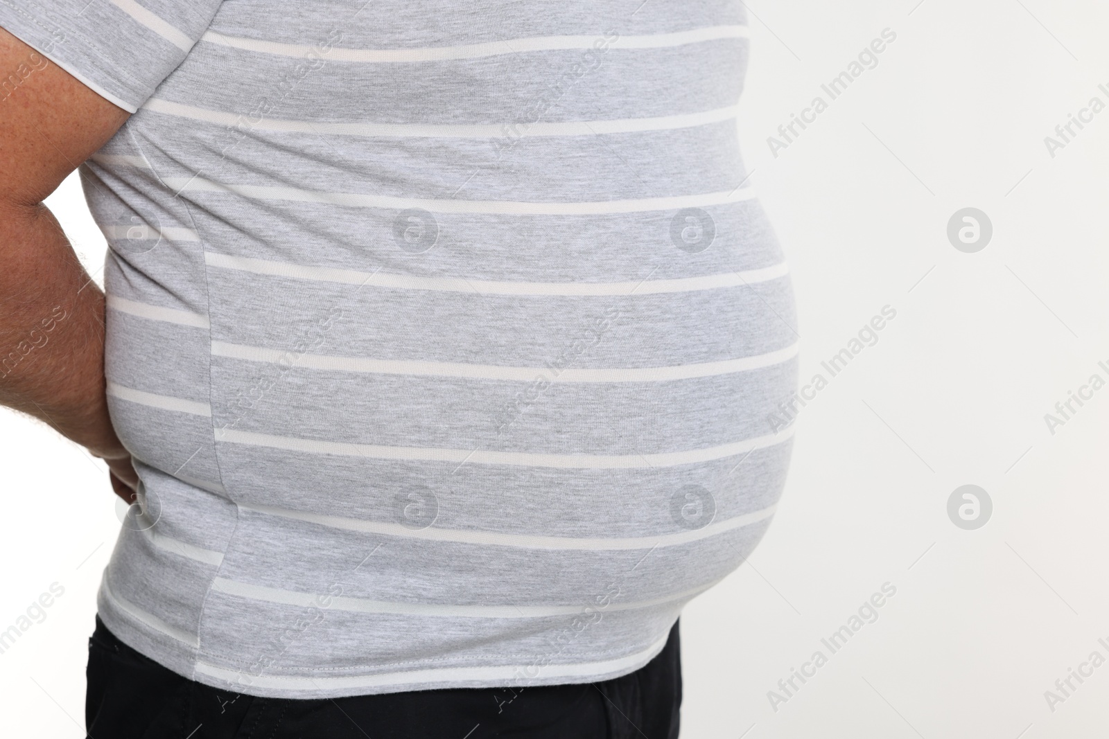 Photo of Overweight man in tight t-shirt on white background, closeup