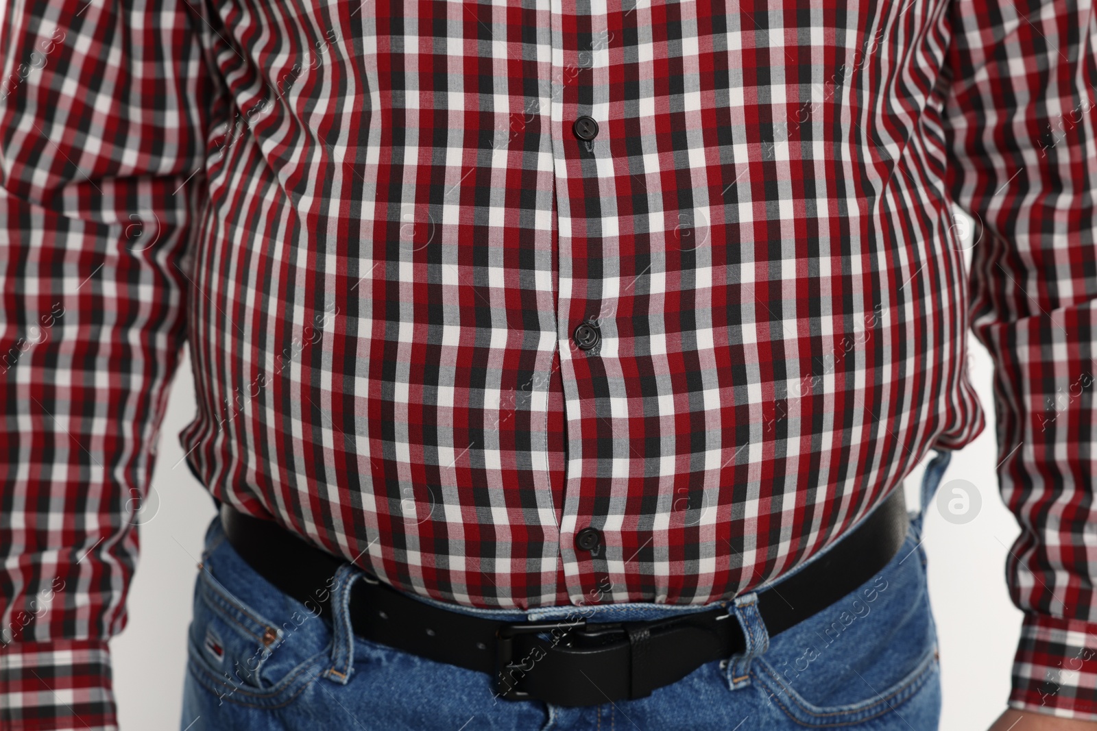 Photo of Overweight man in tight shirt on white background, closeup