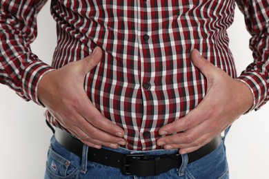 Photo of Overweight man in tight shirt on white background, closeup