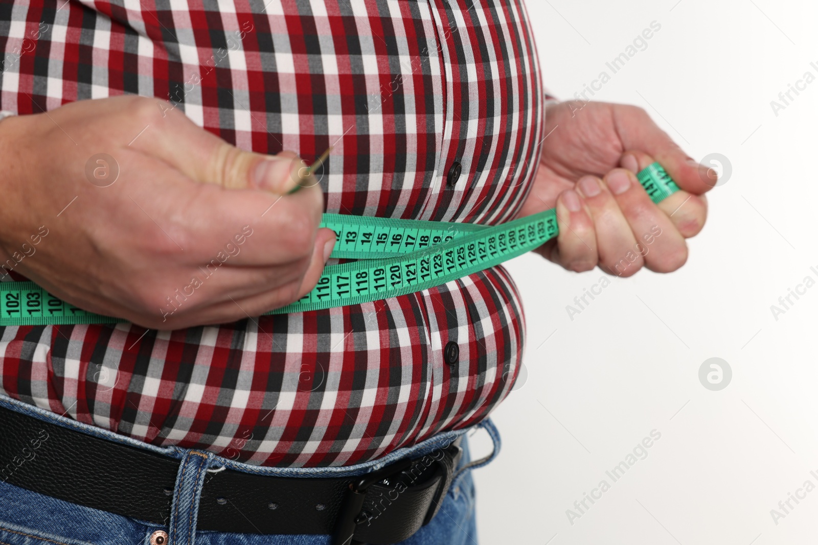 Photo of Overweight man measuring his belly with tape on white background, closeup