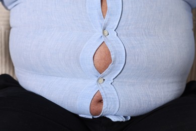 Photo of Overweight man in tight shirt, closeup view