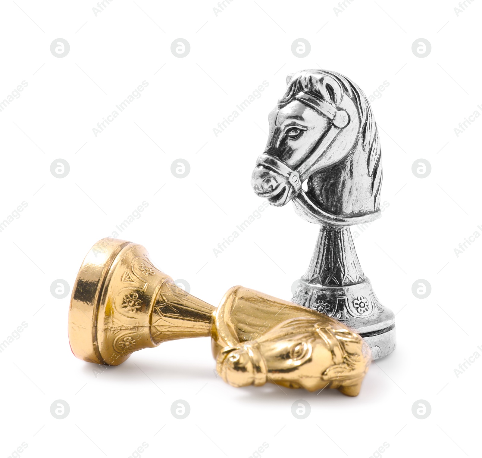 Photo of Golden chess knight near fallen silver one on white background. Competition concept