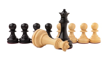 Photo of Black chess queen near fallen white one in front of pawns on white background. Competition concept