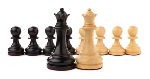 Photo of Black and white chess queens in front of pawns on white background. Competition concept