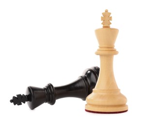 Photo of White chess king near fallen black one on white background. Competition concept