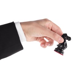 Photo of Man holding chess knight on white background, closeup. Competition concept