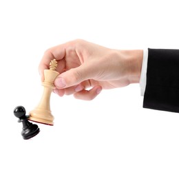 Photo of Man with white chess king knocking over black pawn on white background, closeup. Competition concept