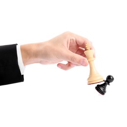 Photo of Man with white chess king knocking over black pawn on white background, closeup. Competition concept