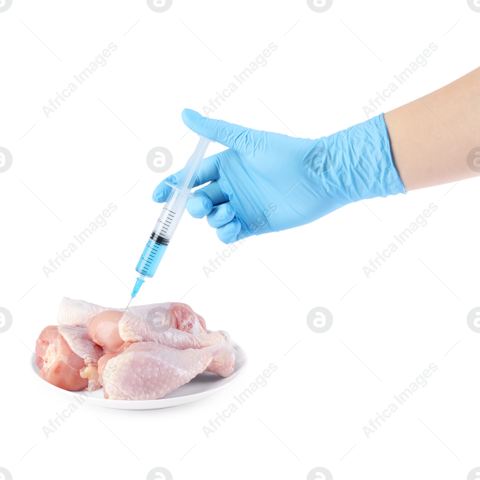 Photo of GMO concept. Scientist injecting something into chicken drumsticks on white background, closeup