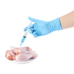 Photo of GMO concept. Scientist injecting something into chicken drumsticks on white background, closeup