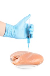 Photo of GMO concept. Scientist injecting something into piece of chicken on white background, closeup