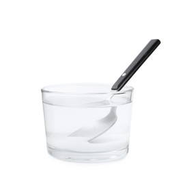 Photo of Glass of water with baking soda and spoon isolated on white