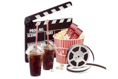 Photo of Tasty popcorn, film reel, clapper, soda drinks and movie tickets isolated on white