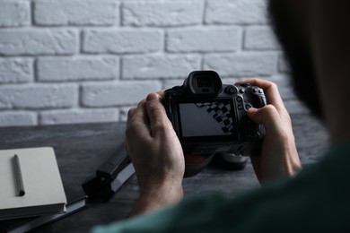 Photo of Photographer with professional camera at gray marble table, closeup