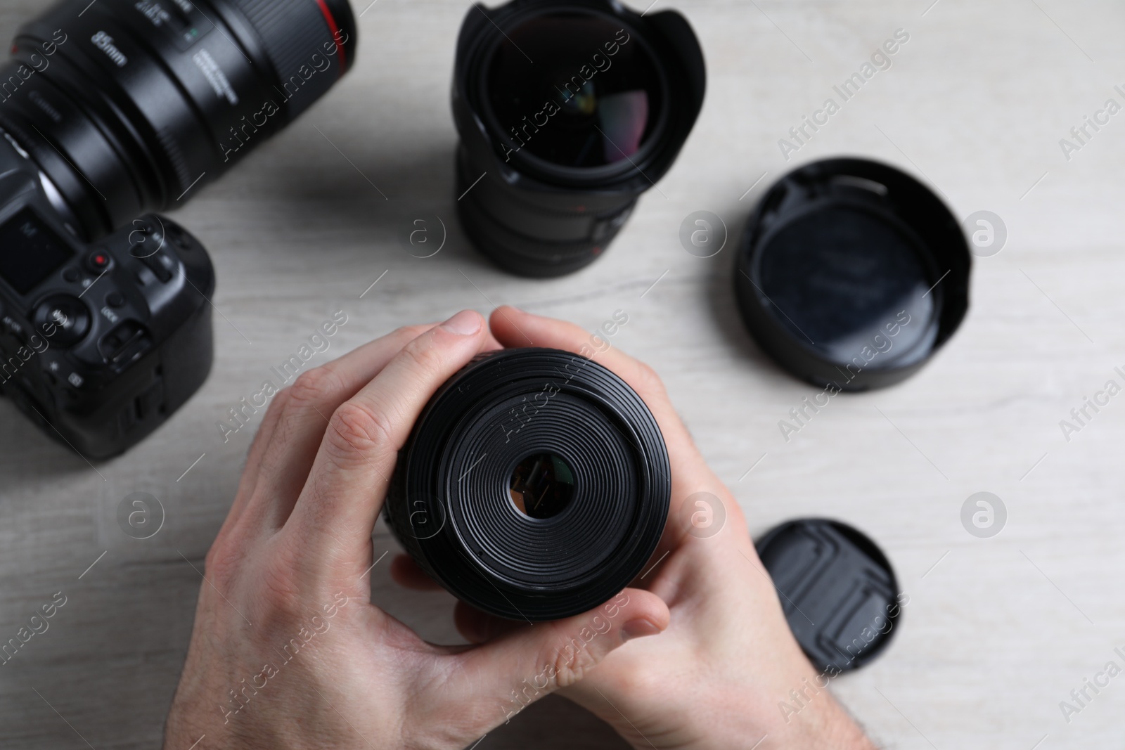 Photo of Photographer with camera lens at wooden table, above view