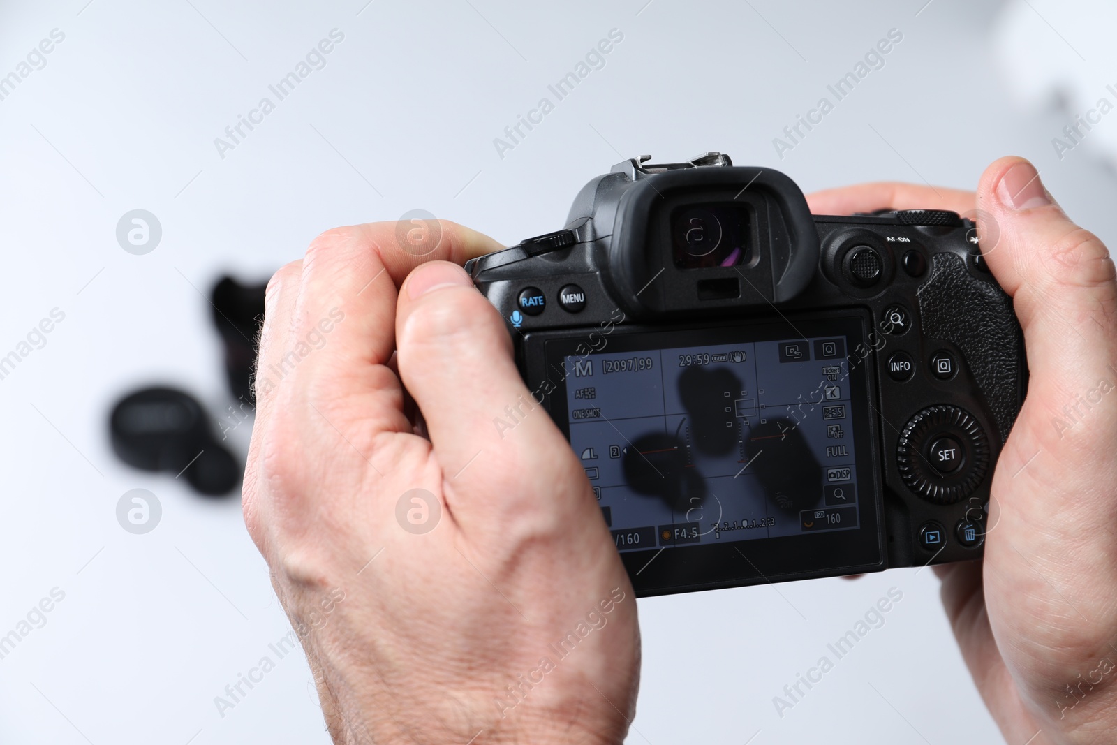 Photo of Photographer taking photo with professional camera on white background, closeup