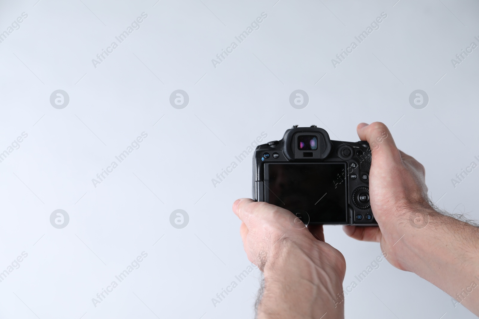 Photo of Photographer with professional camera on white background, closeup. Space for text