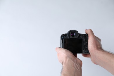 Photo of Photographer with professional camera on white background, closeup. Space for text