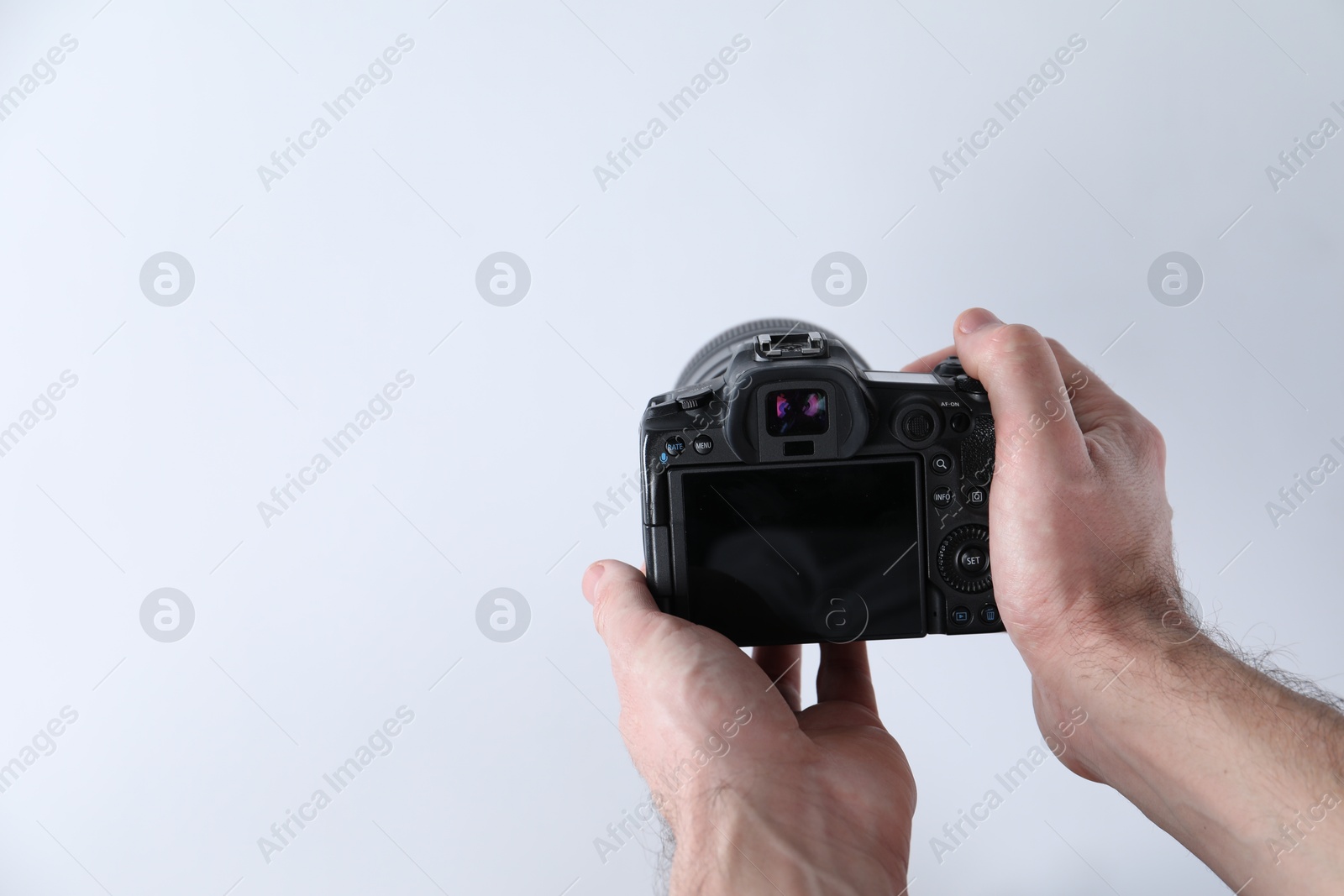 Photo of Photographer with professional camera on white background, closeup. Space for text